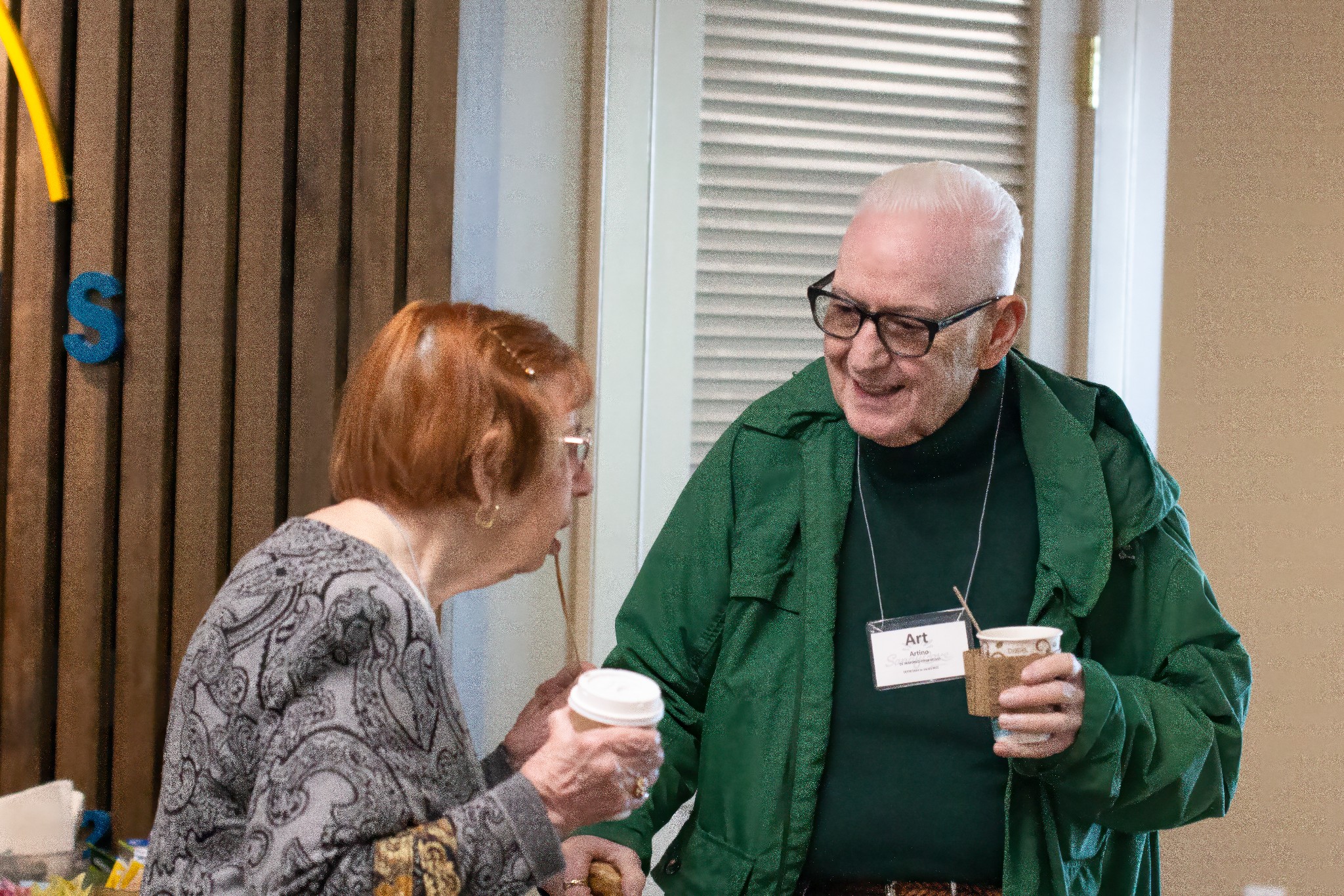 people talking while holding coffee cups